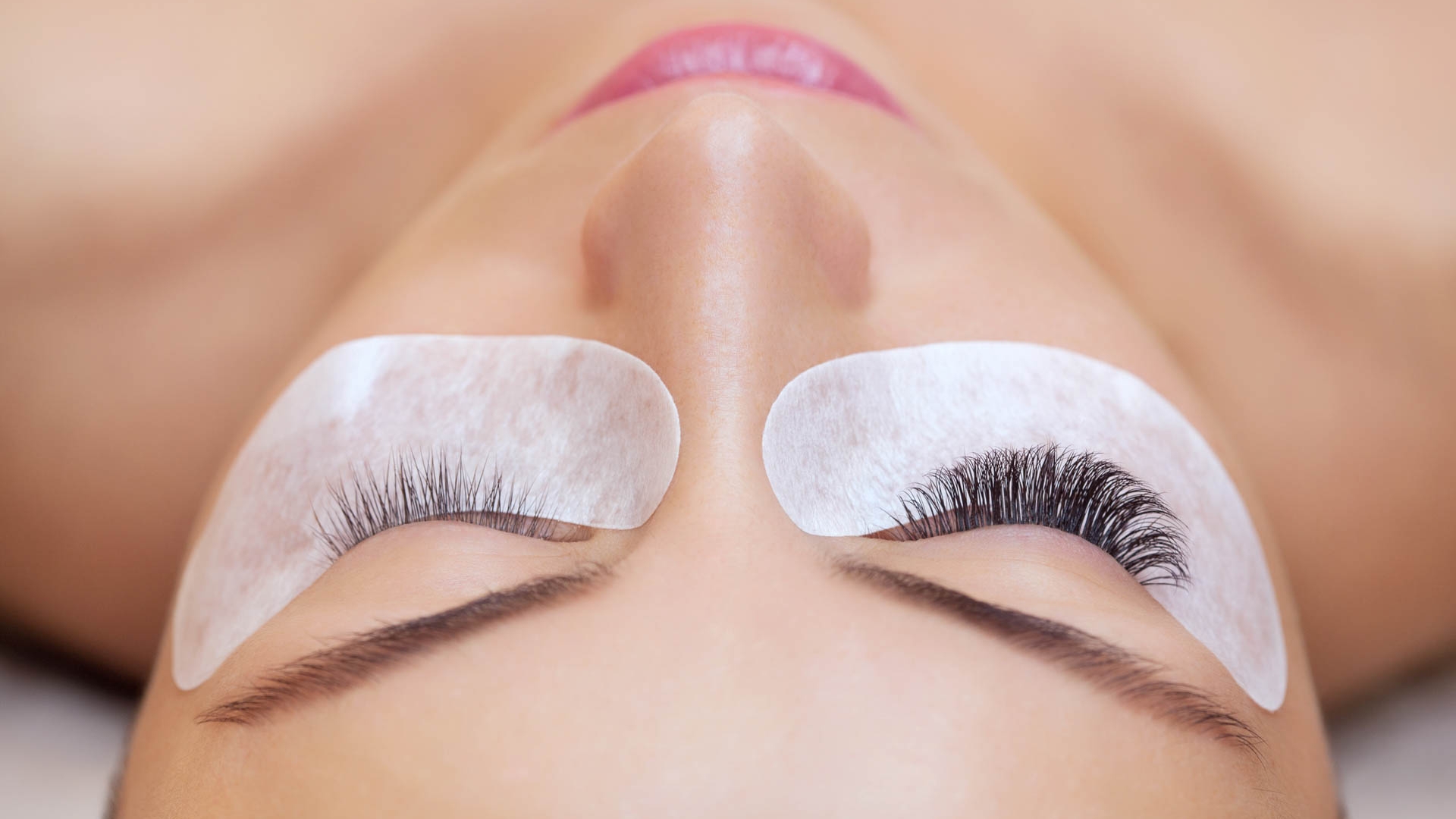 Eyelash removal procedure close up. Beautiful Woman with long lashes in a beauty salon. Eyelash extension.