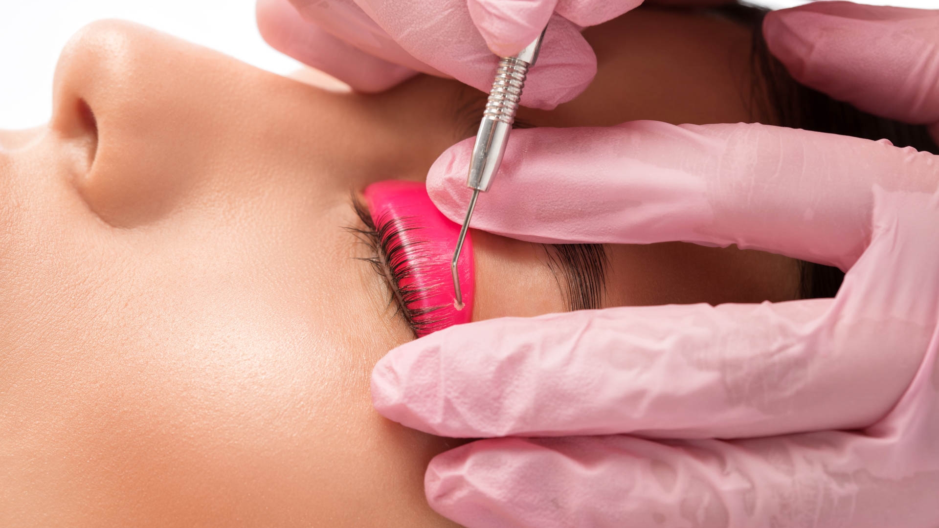 Make-up artist makes the procedure of lamination and dyeing of eyelashes to a beautiful woman in a beauty salon. Eyelash extensions. Eyelashes close-up